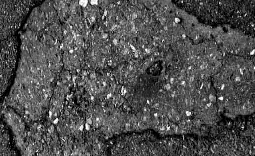 A pothole in an asphalt road surface
