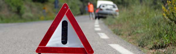A broken down car with a warning triangle behind it